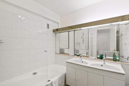 a bathroom with a sink and a tub and a mirror at Suite de Dijon FSHH in Nice