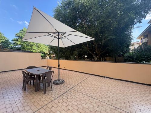 a table and chairs and an umbrella on a patio at Dalla Bibi in Quarto Inferiore