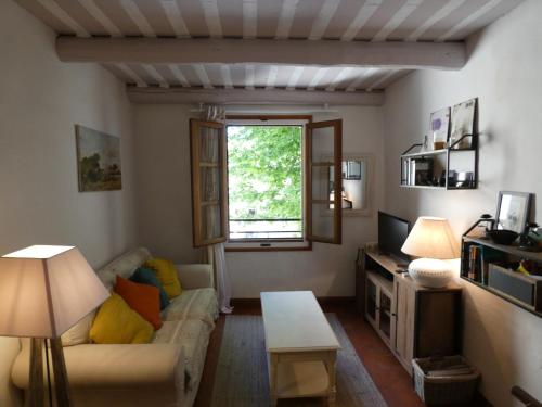 un salon avec un canapé et une fenêtre dans l'établissement Duplex en plein centre, à LʼIsle-sur-la-Sorgue