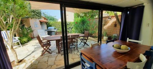 une véranda avec une table et une salle à manger dans l'établissement LE MAZET DU SOLEIL D'OR à 300m plage Nartelle, à Sainte-Maxime