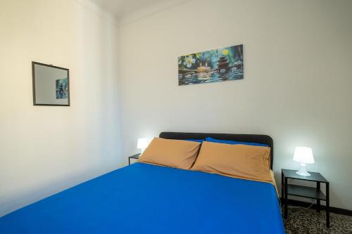 a bedroom with a blue bed and two pictures on the wall at Casa Giorgia with Parking Space in Genova