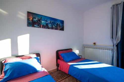 a bedroom with two beds and a tv on the wall at Casa Giorgia with Parking Space in Genova