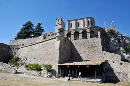 a large building with people standing in front of it at Le Studio de la Baume in Sisteron