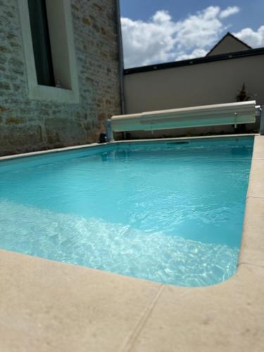 - une piscine avec un banc à côté dans l'établissement Maison avec piscine et cave voûtée, à Perrigny-lès-Dijon
