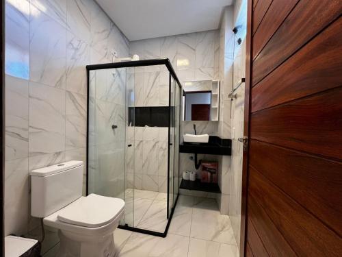 a bathroom with a toilet and a glass shower at Bauten Home Stay Próximo ao Shopping, Centro e Pátio do Forró in Caruaru