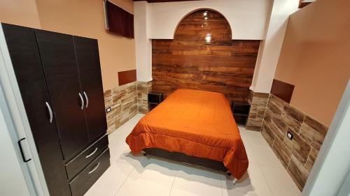 Un dormitorio con una cama y una pared de madera. en Complejo Alicia, en General Gutiérrez