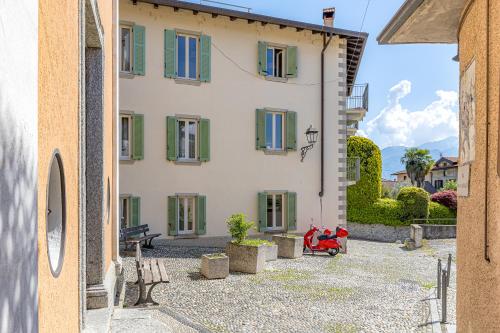 a large white building with green shuttered windows at River House Lenno - Tremezzina - Como Lake in Lenno
