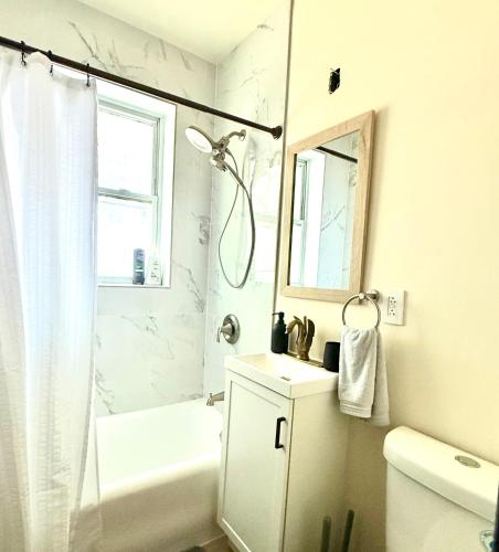 a white bathroom with a shower and a sink at Midway Hideaway -Cozy 1BR- parking in Chicago