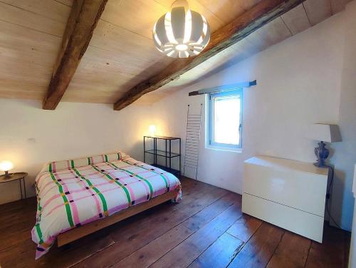 une chambre avec un lit, une commode et une fenêtre dans l'établissement un pied dans la forêt, à La Capelle-et-Masmolène