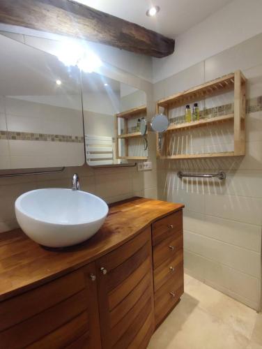 La salle de bains est pourvue d'un grand lavabo blanc sur un comptoir en bois. dans l'établissement un pied dans la forêt, à La Capelle-et-Masmolène