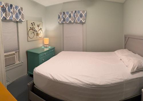 a small bedroom with a bed and two windows at The Tides At Hampton Beach in Hampton