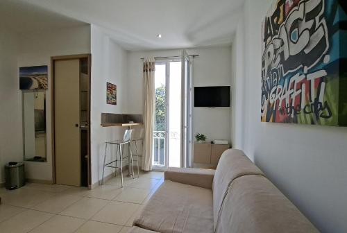 un salon avec un canapé et une télévision dans l'établissement Studio Palais Jocelyn, cosy,moderne, Hyper centre, 3 min à pieds mer et Vieux Nice, à Nice