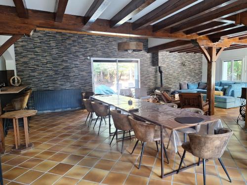 un salon avec une grande table et des chaises dans l'établissement Superbe maison familiale, à Les Sciauds