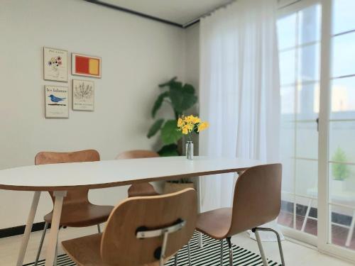 a dining room with a white table and chairs at Soo Stay in Daegu