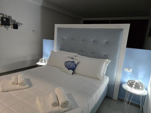 a bedroom with a white bed with towels on it at Domo Annalisa in Tortolì