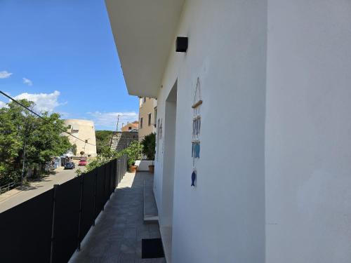 a balcony with a white wall and a sidewalk at Domo Annalisa in Tortolì
