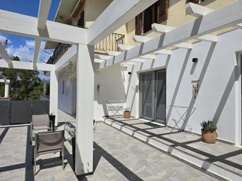 a patio of a house with a white pergola at Domo Annalisa in Tortolì