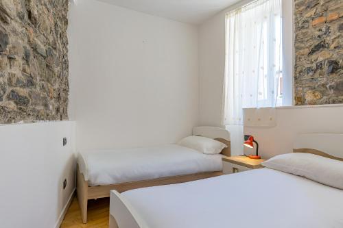 a white room with two beds and a window at River House Lenno - Tremezzina - Como Lake in Lenno