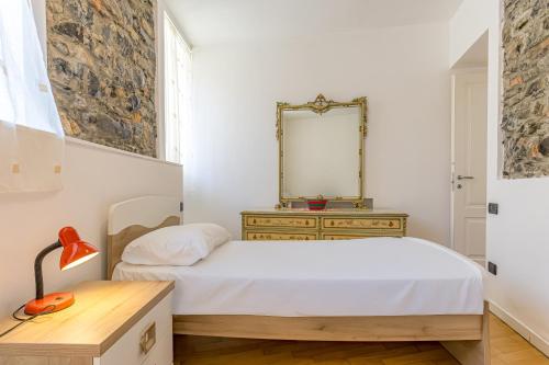a bedroom with a bed with a mirror and a dresser at River House Lenno - Tremezzina - Como Lake in Lenno