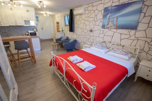 una camera da letto con un letto rosso e una cucina di A&D Apartments a Rovigno (Rovinj)