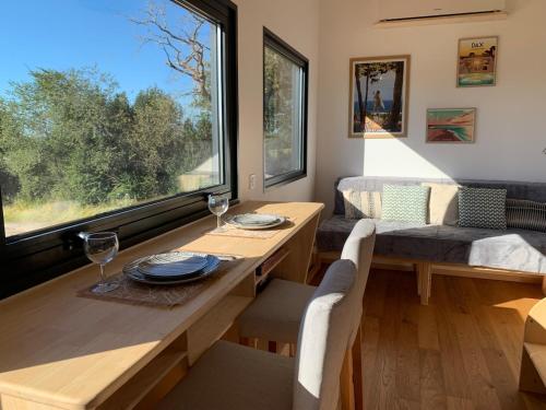 Una sala de estar con una mesa y una gran ventana. en Tiny House Lou Cabanot, en Goos