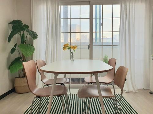 a white table and chairs in a room with a window at Soo Stay in Daegu