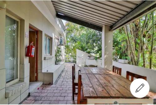 a porch with a wooden table and chairs on a house at St Lucia Safari Lodge Holiday Home in St Lucia