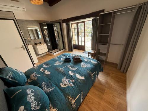 une chambre avec un lit avec une couette bleue dans l'établissement Chambre d'hôtes NATURISTE Le Jardin Des Hirondelles, à Blanzaguet-Saint-Cybard-le-Peyrat