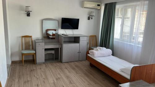 a bedroom with a desk and a bed with a mirror at отель Voyage in Shymkent