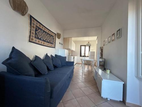 a living room with a blue couch and a television at CASA VIOLA Two-room apartment with a sea view in La Marmorata