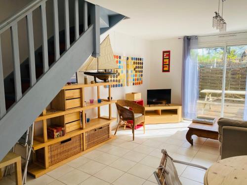 un salon avec un escalier et une table dans l'établissement Charmante maison plage, à Contis-les-Bains
