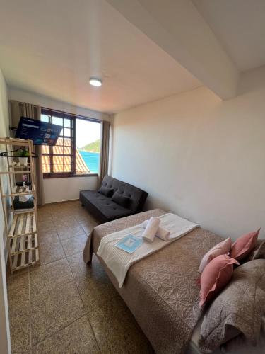 a bedroom with a bed and a view of the ocean at Estalagem pé na areia in Arraial do Cabo