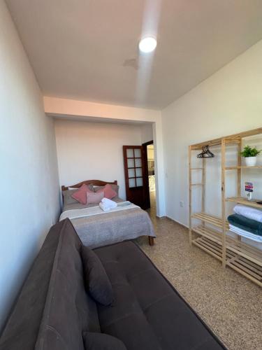 a bedroom with a bed and a couch at Estalagem pé na areia in Arraial do Cabo