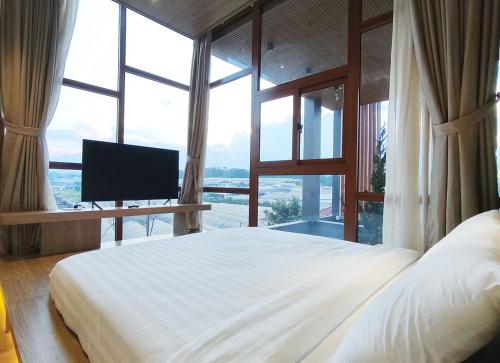 a bedroom with a large bed with a television in it at Meraki Villa Đà Lạt in Khu Chi Lăng