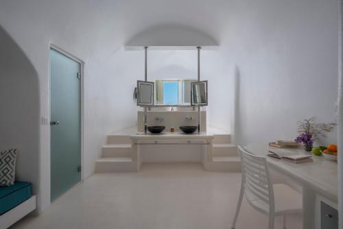 a living room with a table and a television at Diamond Luxury Suites Collection in Oia