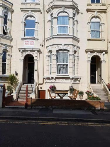 a white building with a table in front of it at Abbey Lodge Guest House in Bournemouth