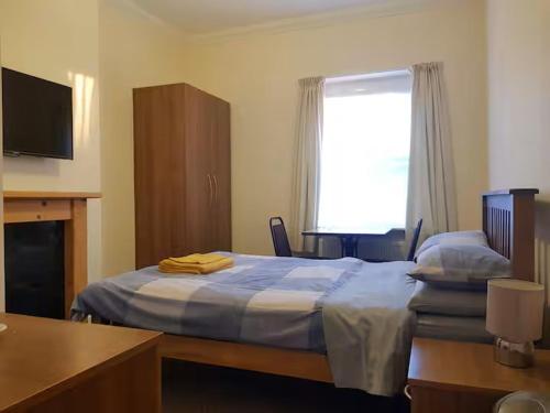 a hotel room with two beds and a window at Abbey Lodge Guest House in Bournemouth