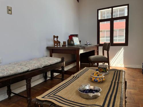 a room with a desk and a table with a bowl of fruit at El Pueblito in Cochabamba