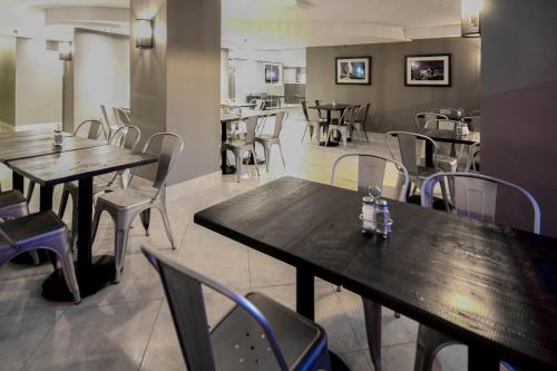 a restaurant with wooden tables and chairs in a room at Hotel Faubourg Montreal Centre-Ville Downtown in Montréal