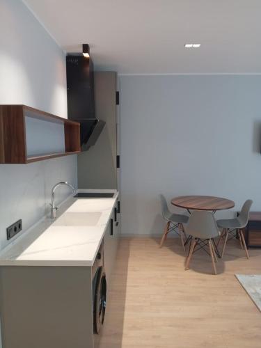a kitchen with a sink and a table with chairs at Апартаменты в Батуми на берегу моря Mziuri Gardens in Itʼkhvisi