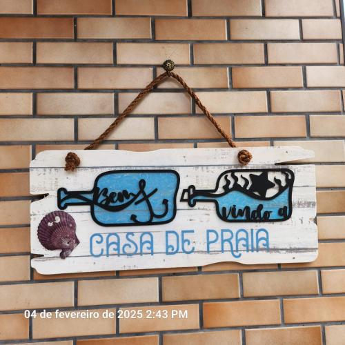 a sign that is hanging on a brick wall at Sobrado Aviação piscina, churrasqueira, jacuzzi in Praia Grande