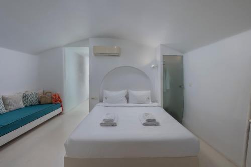 a white room with a bed and a couch at Diamond Luxury Suites Collection in Oia
