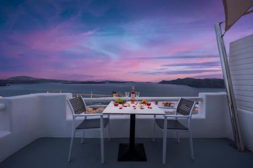 a table and chairs on the balcony of a boat at Diamond Luxury Suites Collection in Oia