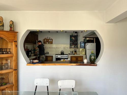 a man standing in a kitchen with a mirror at El Pueblito in Cochabamba