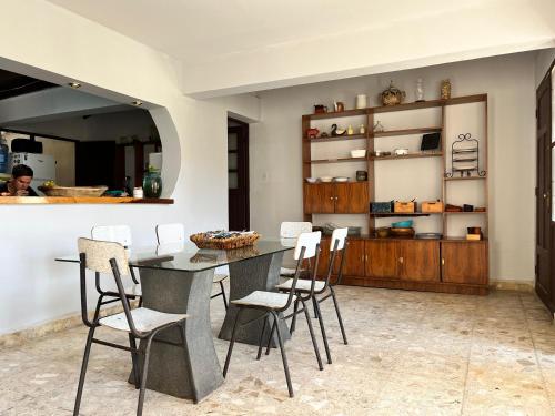a dining room with a table and white chairs at El Pueblito in Cochabamba