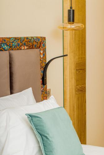 a bed with a blue pillow next to a lamp at Moulin de Cambelong- Emilie & Thomas in Conques-en-Rouergue