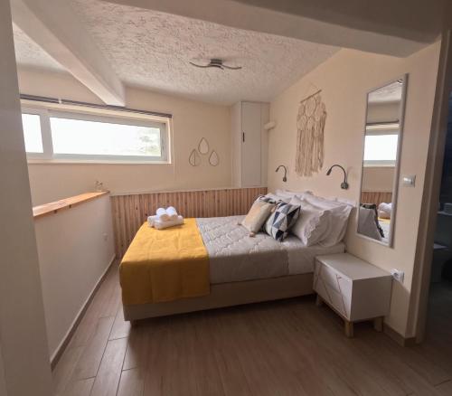 a bedroom with a bed and a window and a mirror at Almyra in Finikounta