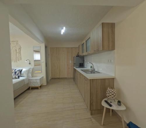 a kitchen with a sink and a couch in a room at Almyra in Finikounta