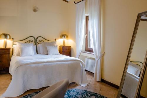 a bedroom with a white bed and a mirror at Agriturismo Antica Dimora Del Turco in Sona