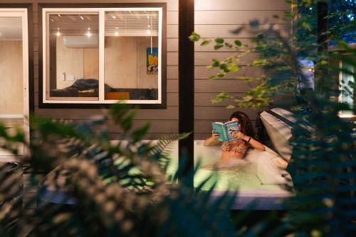 Una mujer tomándose una foto en una bañera. en Sauk River Cabins - Hot tub - Firepit, en Darrington